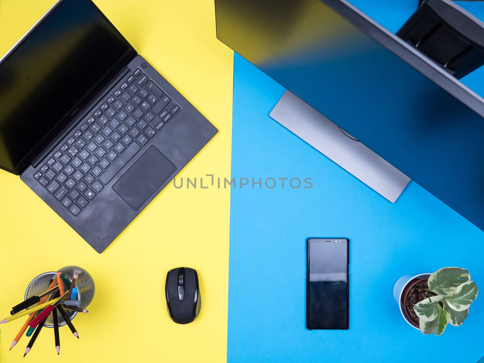 Flat lay top view of business man workplace concept over blue background. Modern laptop. Freelancer phone.
