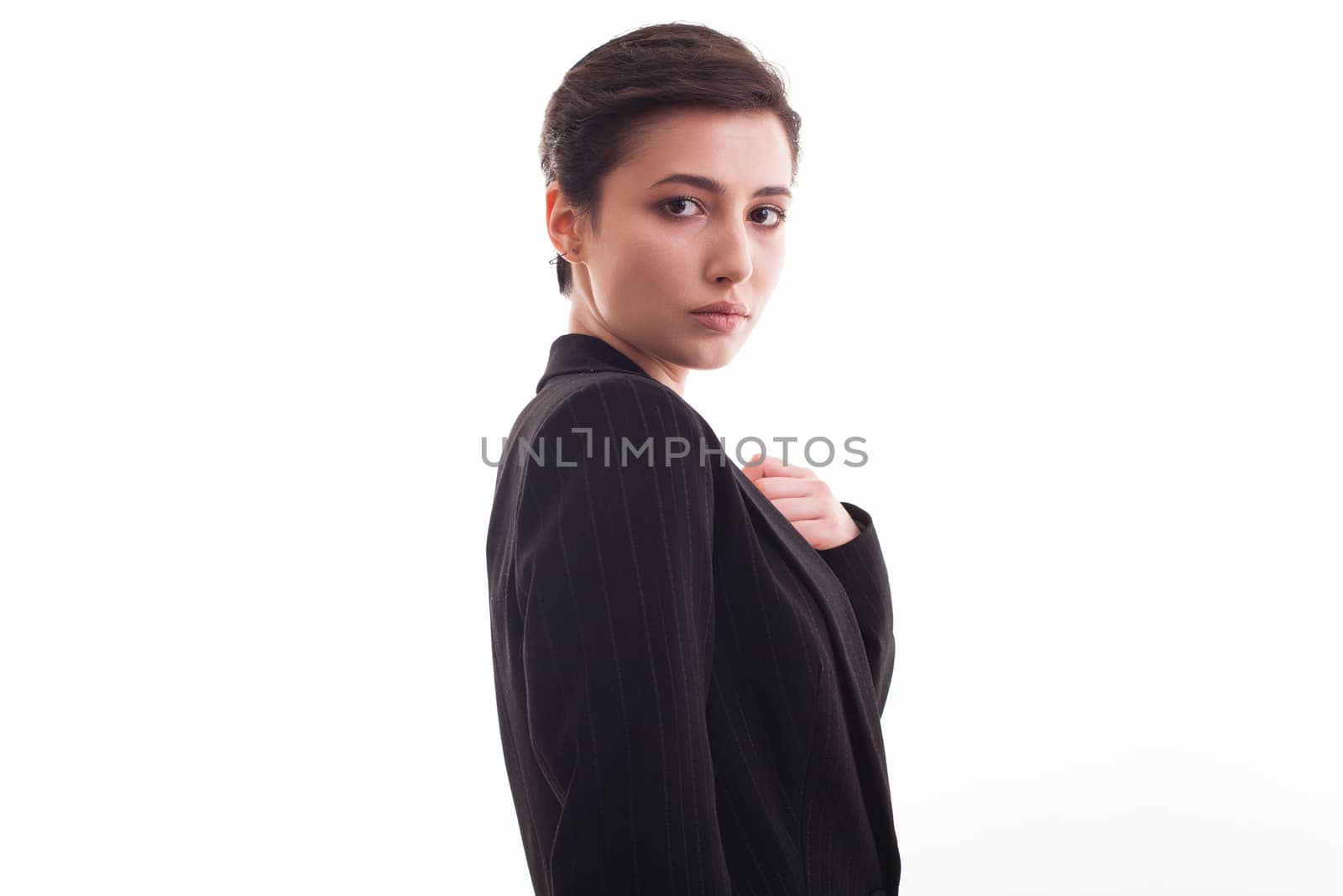 Side view portrait of beautiful young woman wearing a black jacket over white background. Caucasian beautiful woman in studio.
