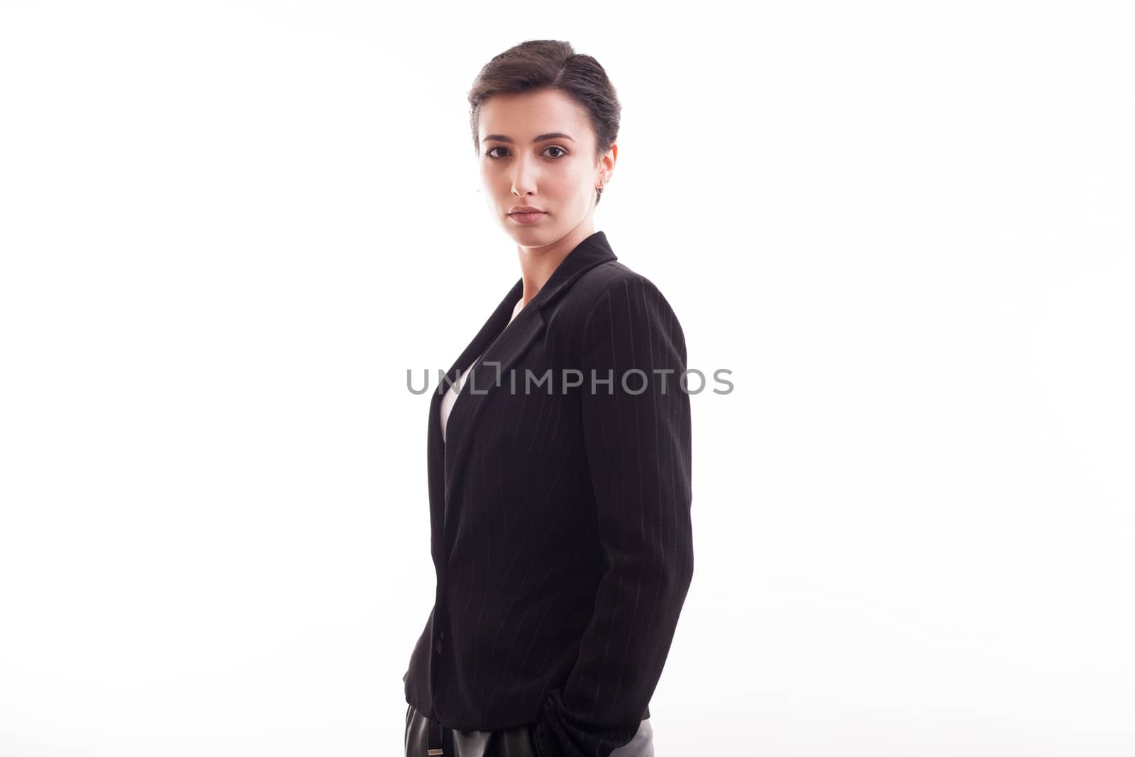Gorgeous young fashion model looking at the camera wearing a black jacket in studio over white background. Pretty girl.