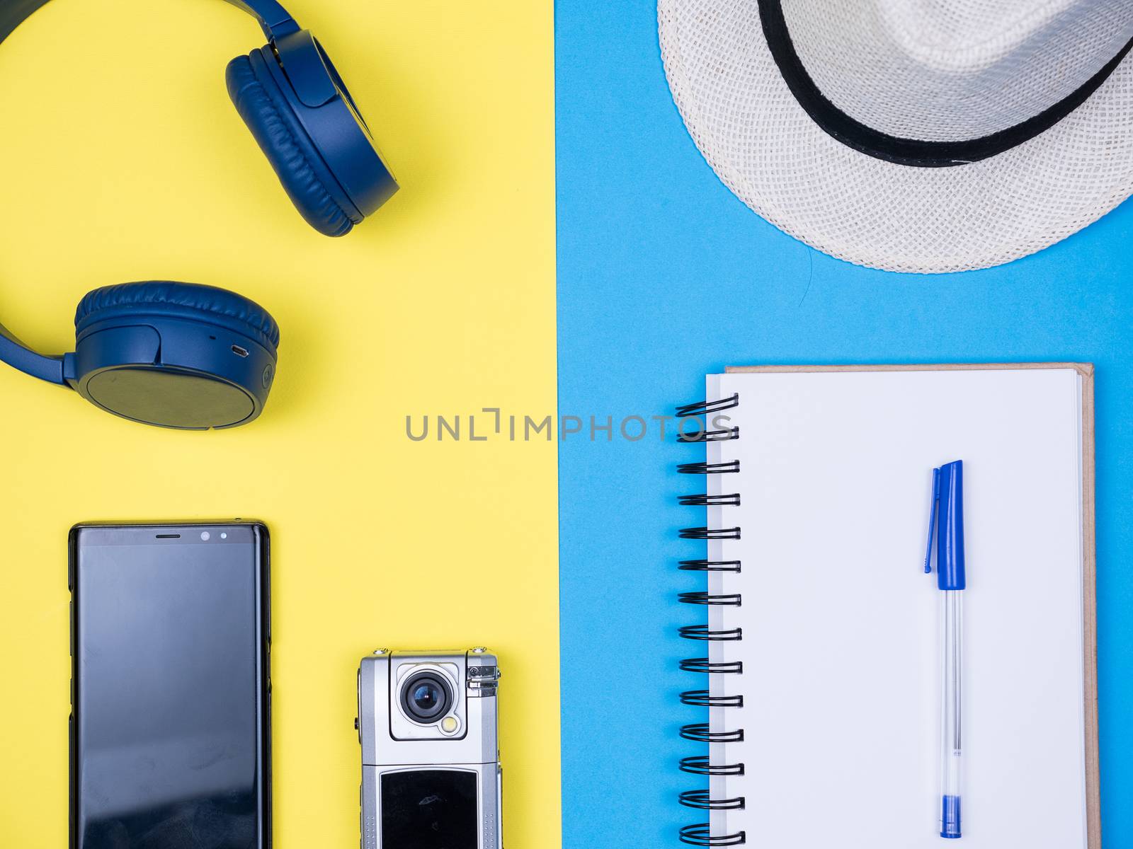 Flat lay top view traveler journal over blue background. Small traveler camera.