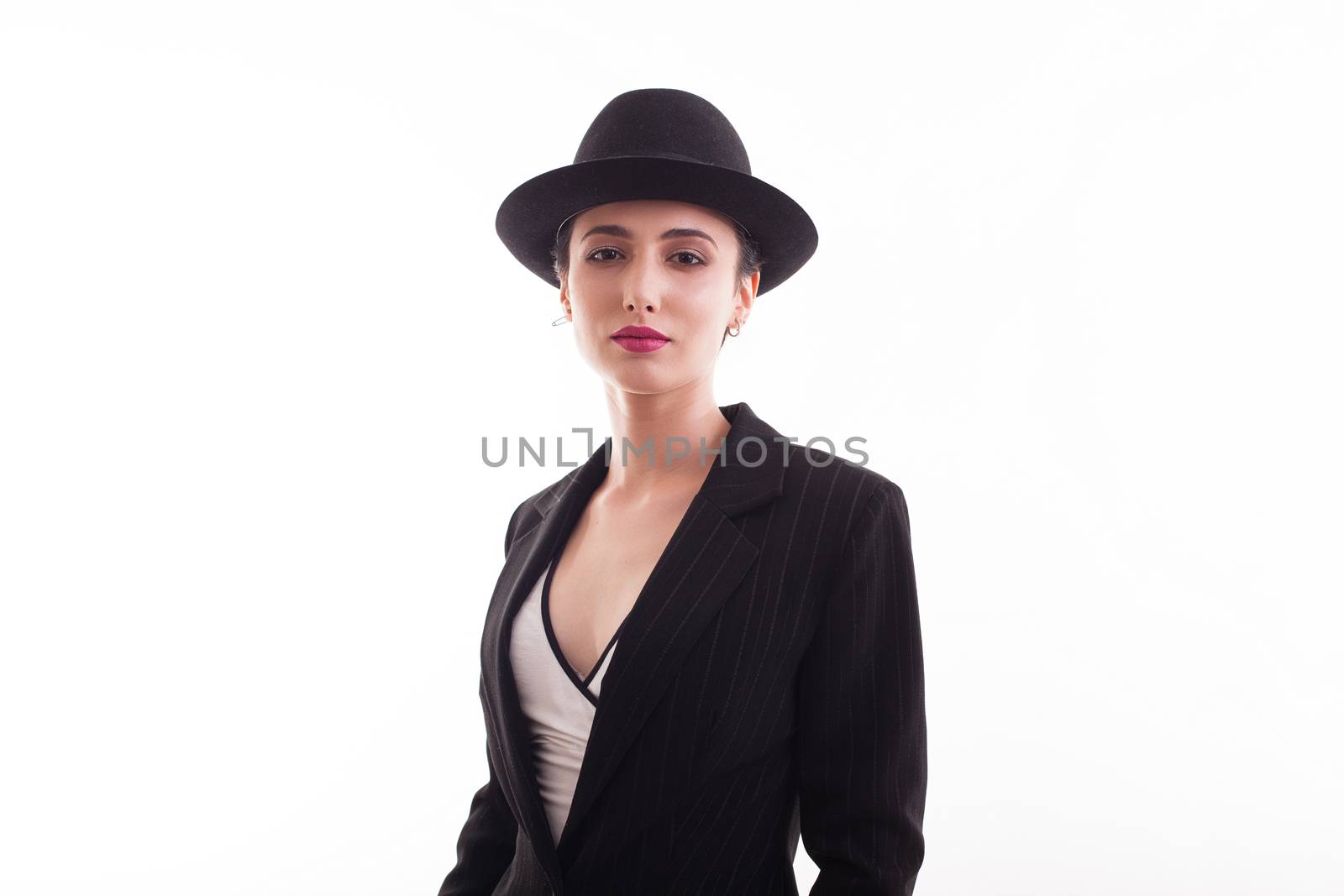 Stylish fashion model wearing a hat over white background in studio. Fashionable woman.