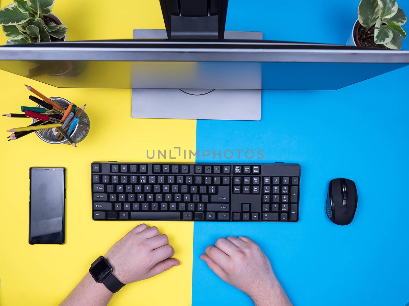 Flat lay top view of man holding hands on his desk. Office concept. Freelancer at work.
