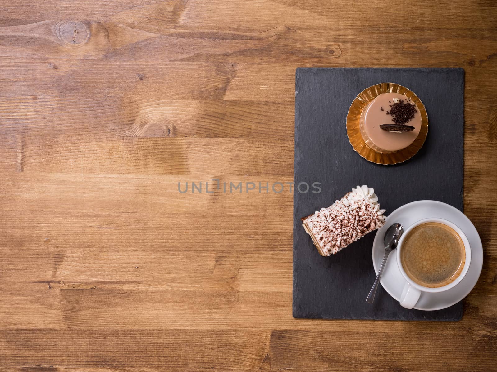 Top view of a cup of coffee near two different chocholate cakes on wooden table. Tasty desert. Delicious cake. Fresh cakes. Copy space available.