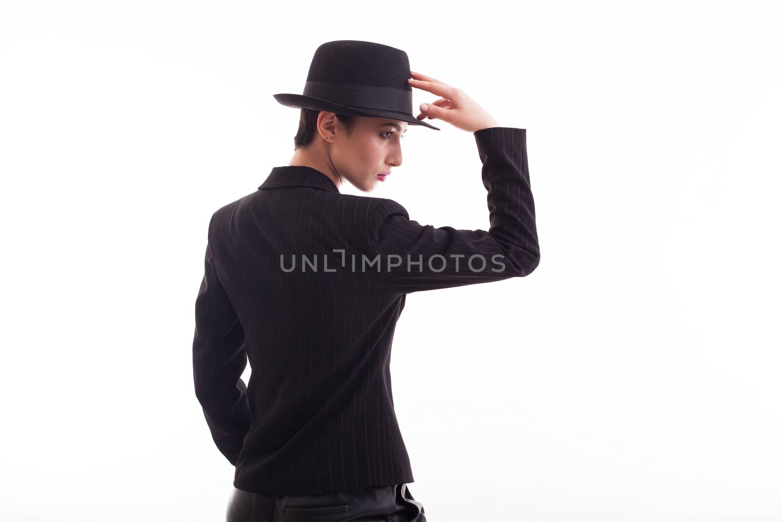 Beautiful fashion model posing in studio over white background with retro hat. Stylish clothing.