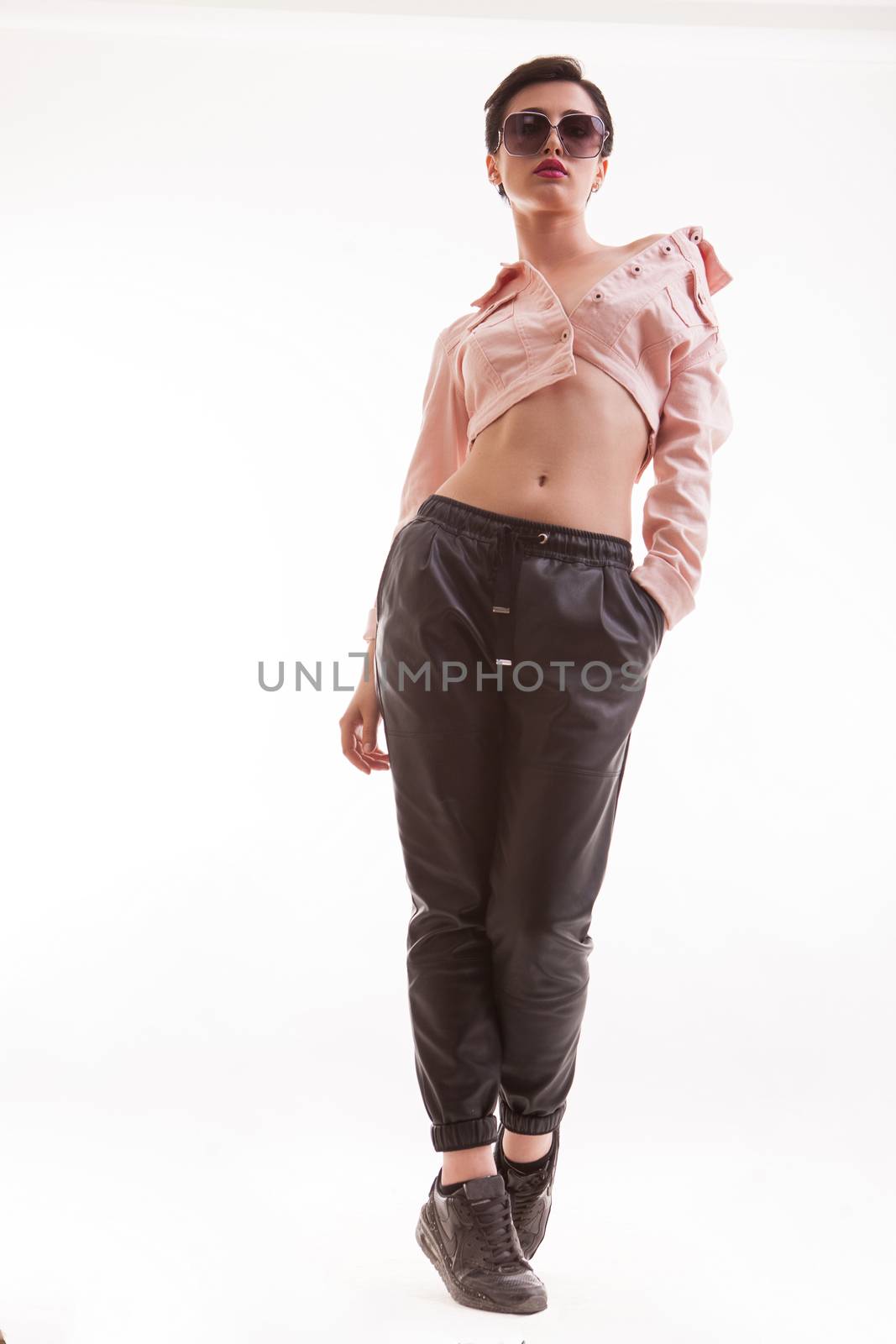 Full body portrait of beautiful fashion modeling looking down on the camera wearing a stylish pink jacket. Sexy clothing style. Feminine looking.