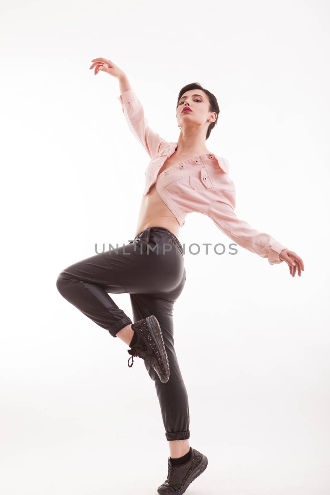 Beautiful fashion model posing withhands in the air with a stylish jacket over white background in studio. Casual and fashionable clothing.