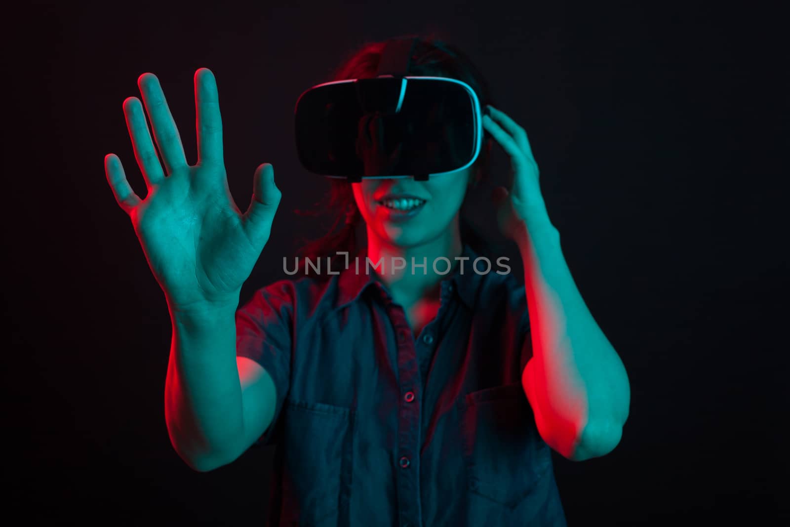 Cheerful young woman surprised while watching a movie using virtual reality headset. Joyfull entertainment with virtual reality helmet.