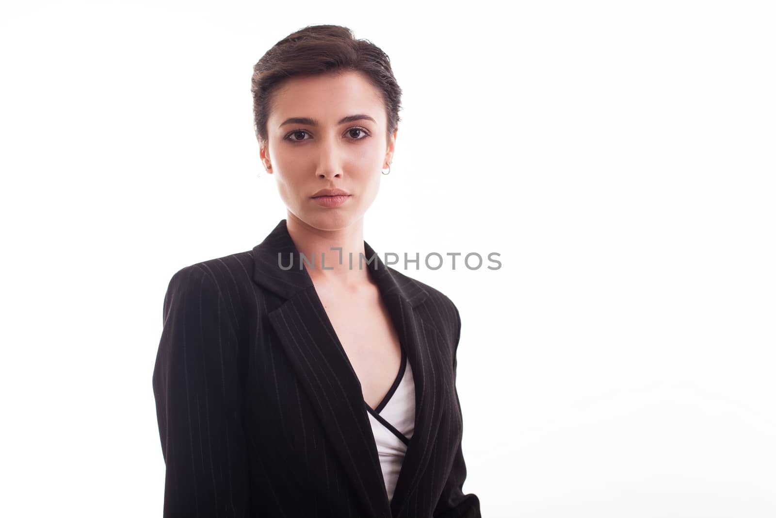 Portrait of beautiful young lady wearing a stylish costume jacket. Caucasian woman posing in front of the camera over white background.