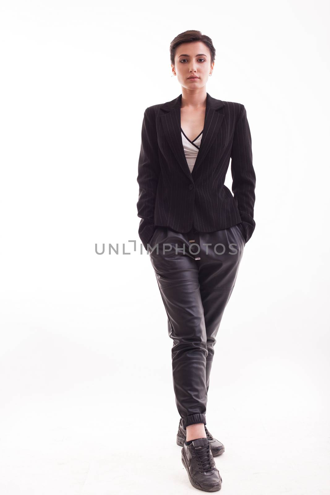 Full body of beautiful young woman wearing a pair of black leather pants over white background. Full lenght of elegant beautiful young woman.