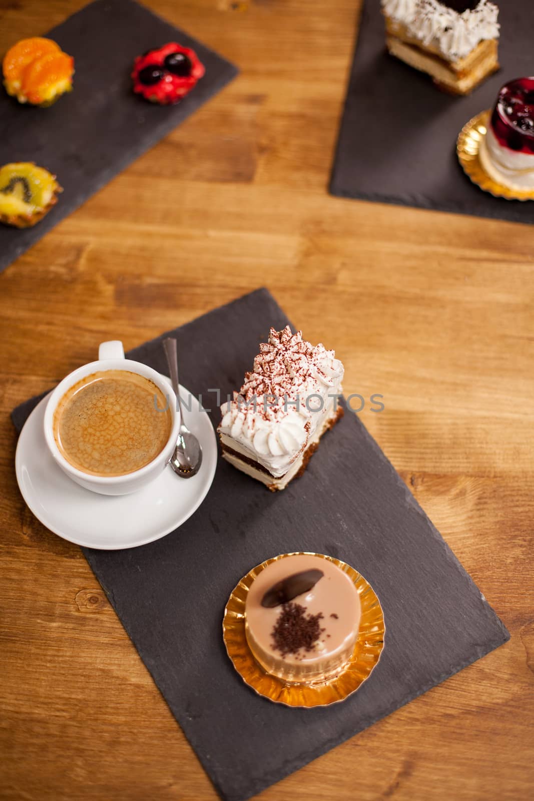 Sweet desserts on a wooden table in a coffee shop near tasty cup of coffee. Homemade desserts in a coffee shop. Tasty chocholate cake.