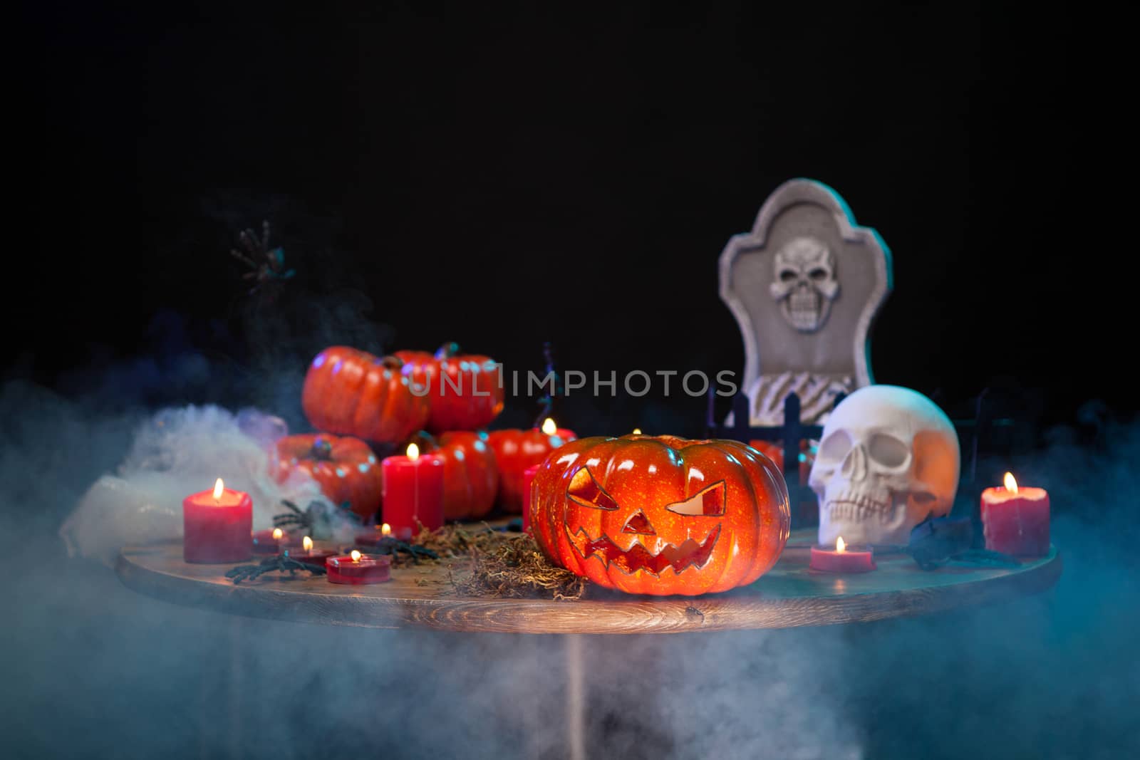 Horror scene with scary pumpking on a wooden table for halloween celebration. Halloween candles.