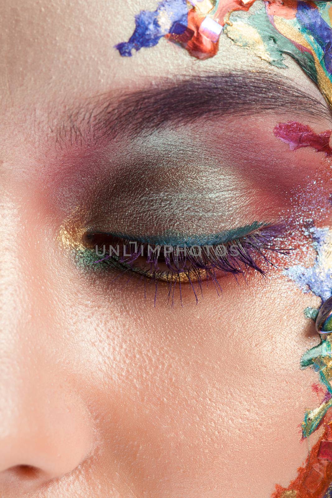 Beautiful woman with creative makeup on her face in studio. Abstract makeup.