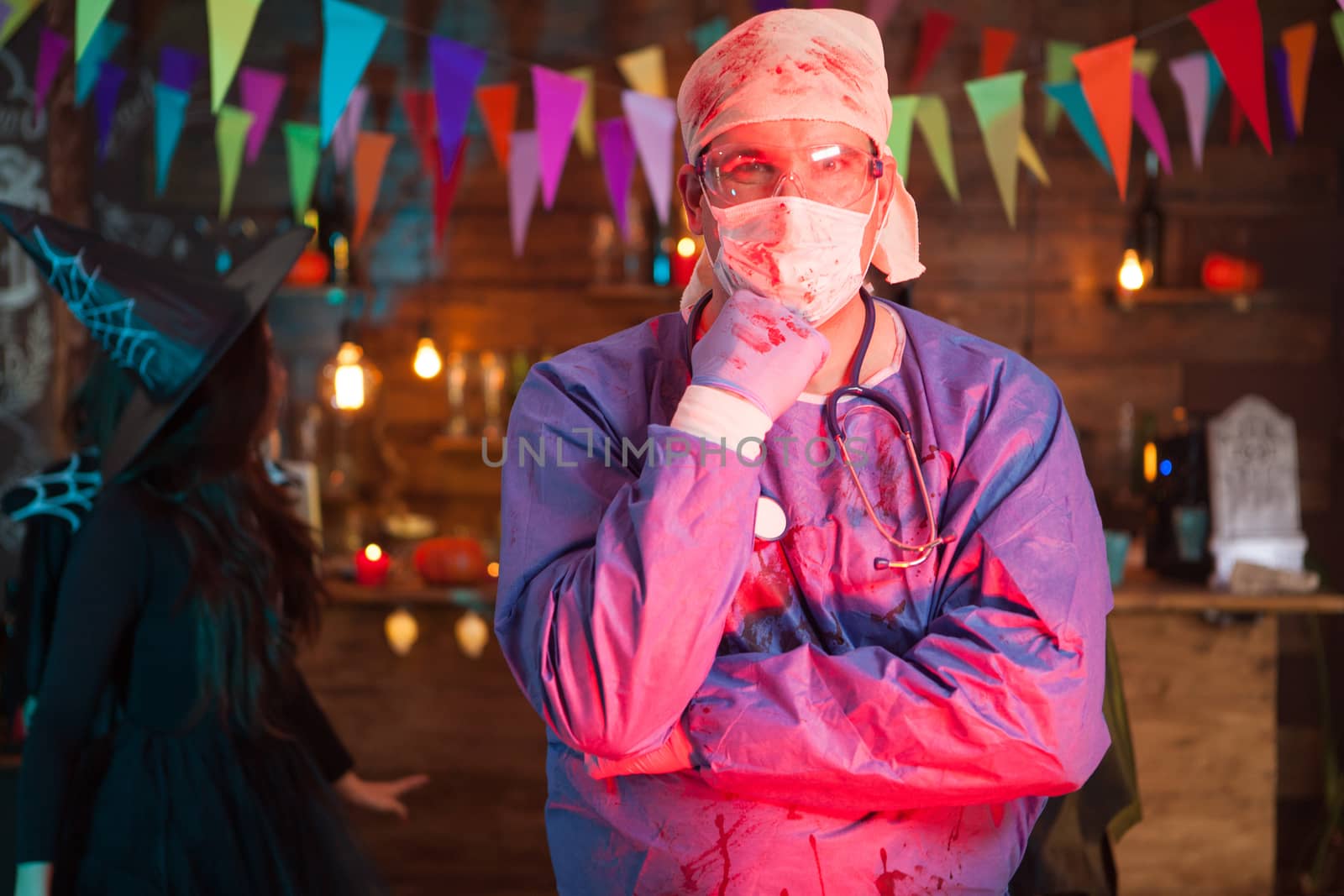 Thoughtful young man in a doctor costume celebrating halloween. Celebrating halloween in a night club.