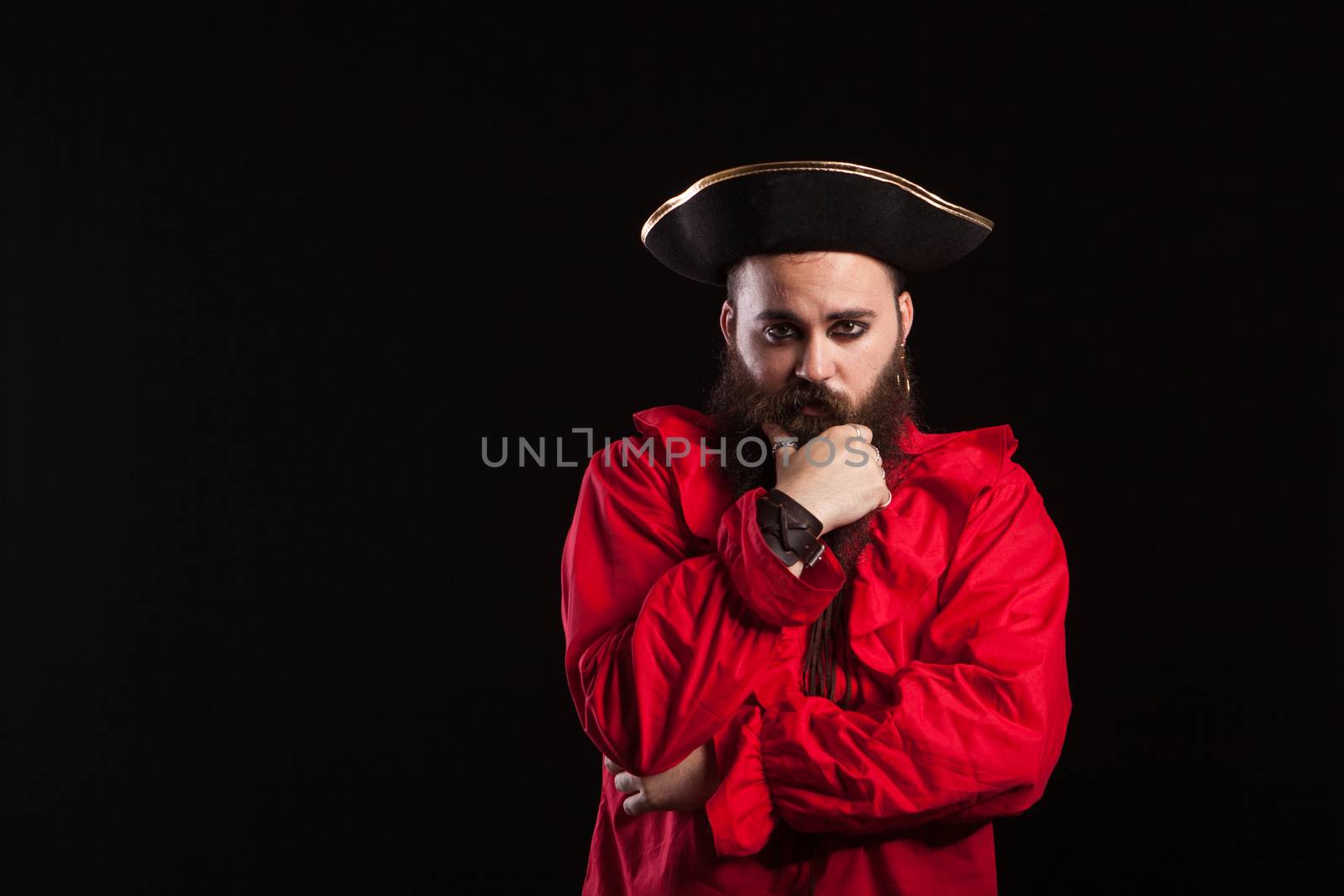 Man with a serious face dressed up like a caribbean sailor for halloween. Actor dressed up like a pirate.