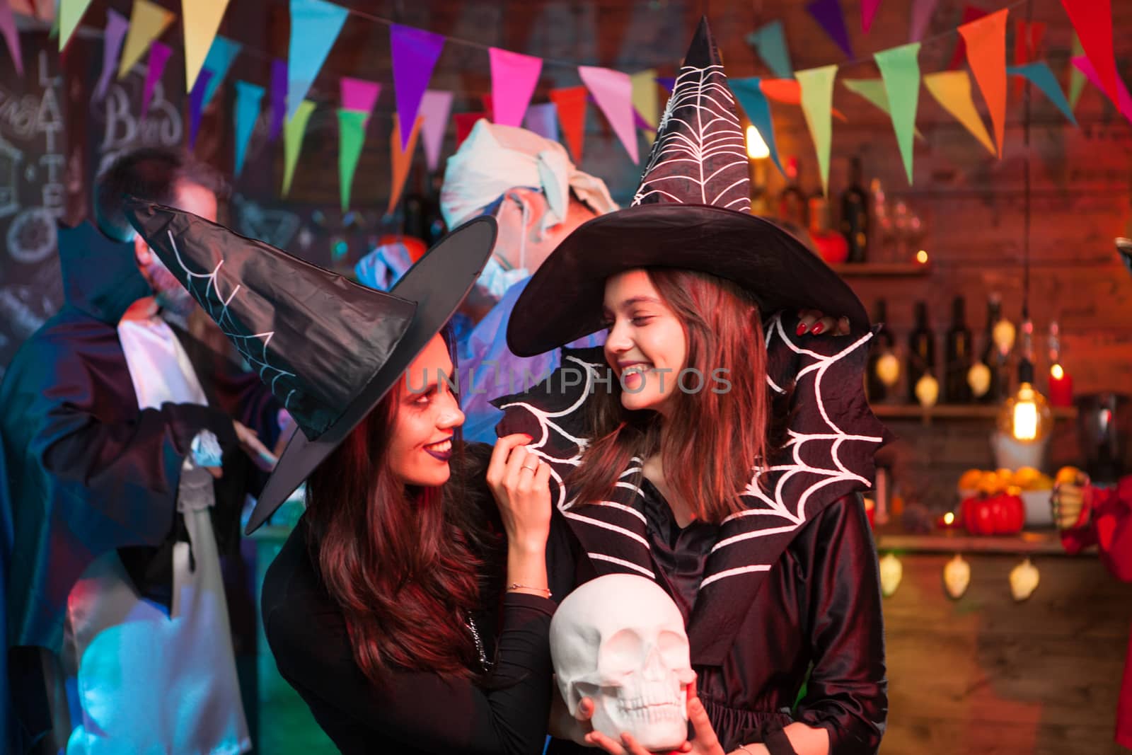 Two witches having a good time together at halloween party by DCStudio