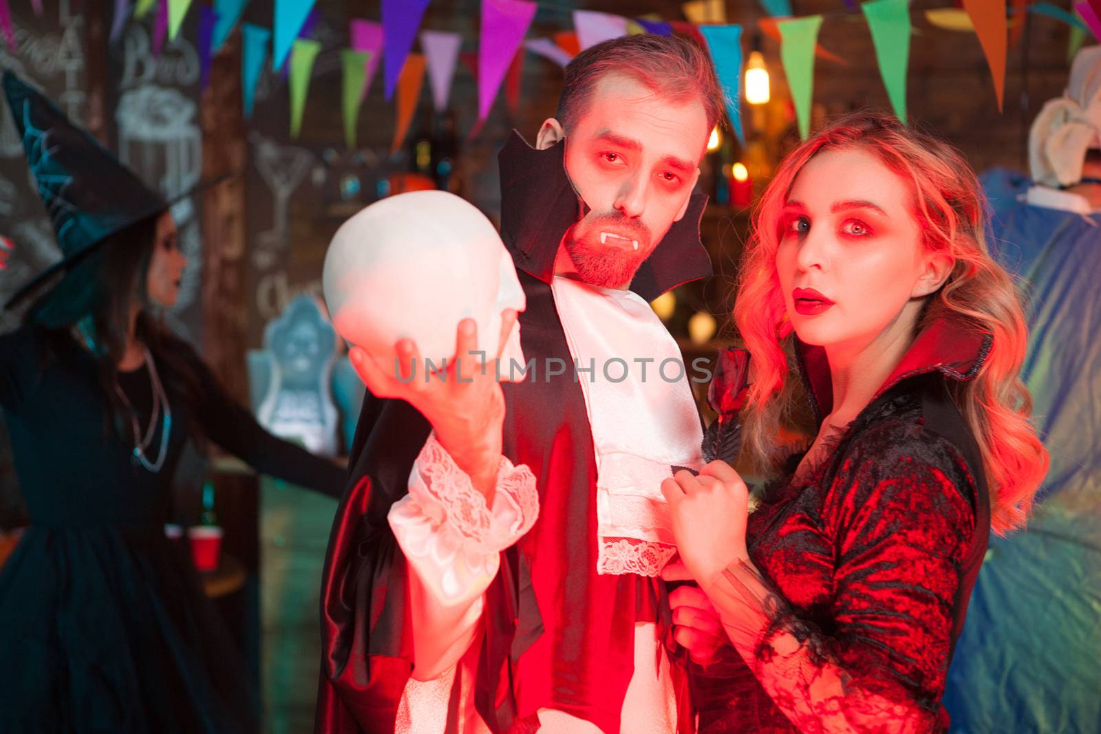 Attractive young couple dressed up like vampire costumes for halloween celebration. Halloween monsters gathering.