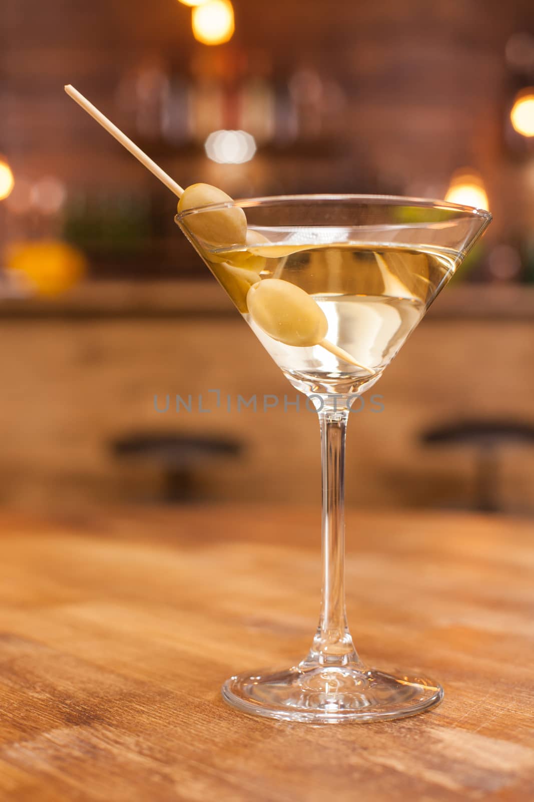 Alcoholic martini cocktail on a rustic wooden table in a restaurant. Fresh drink. Relaxing drink.