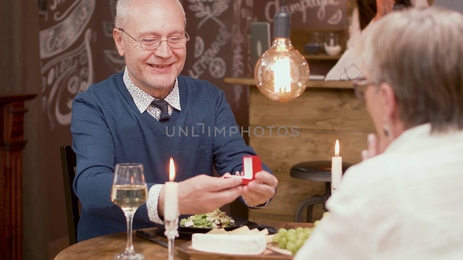Senior man asking his wife to mary him again after all of this years of marriage. Old couple. Couple in their sixties.