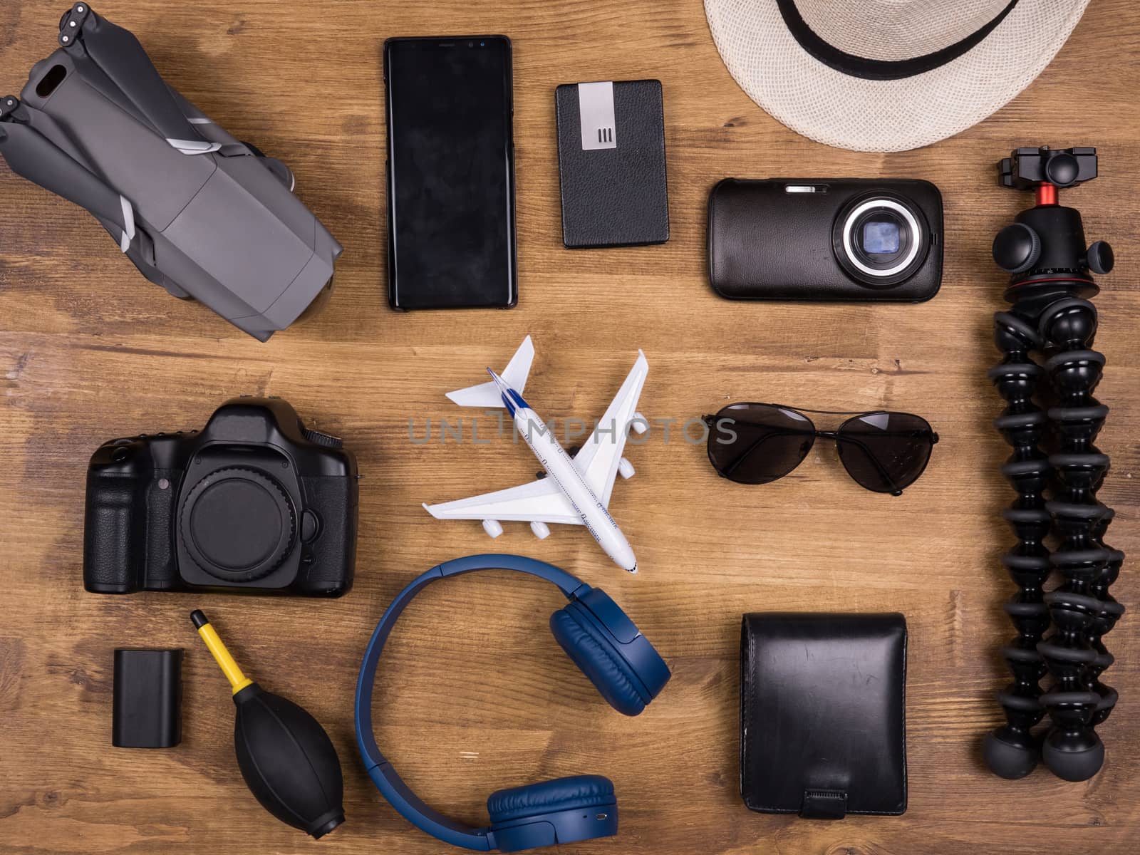Top view of different film maker accessories over wooden table. Modern camera. Modern drone. Headset