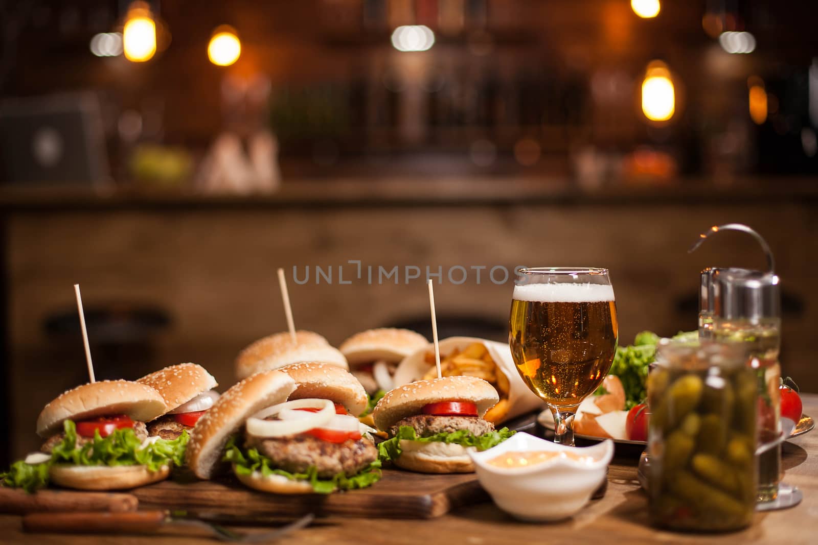 Tasty burgers with green salad on wooden table. Delicious burgers. Frenchs fries.