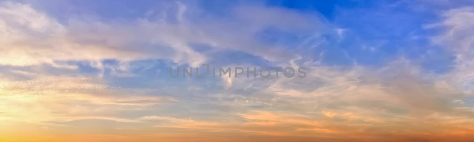 Beautiful high resolution panorama of orange and red sunset clouds in the evening sky.