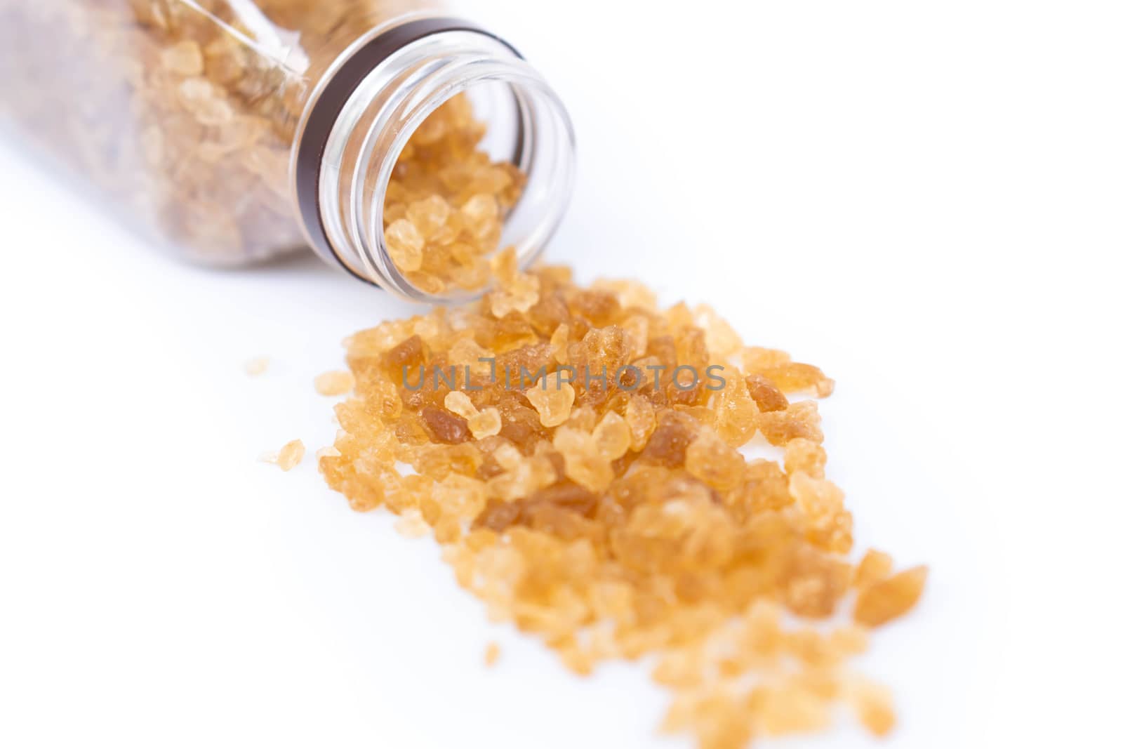 Closeup brown sugar with bottle on white background, healthy concept, selective focus