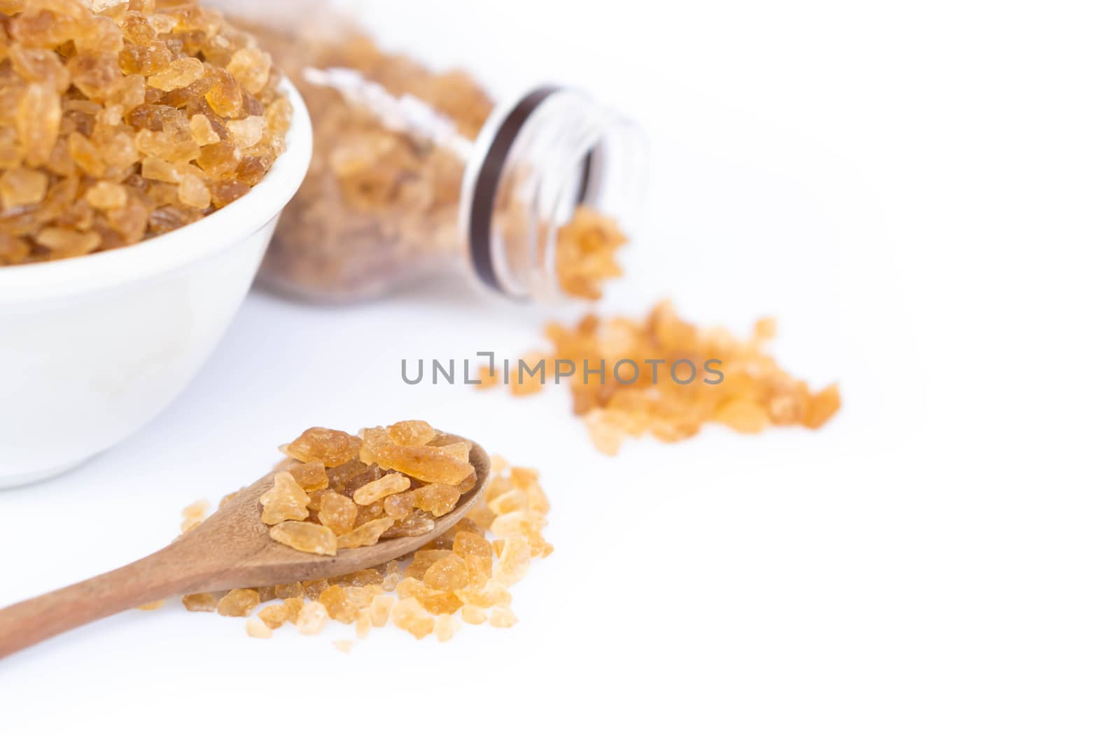 Closeup brown sugar on wood spoon with bottle and bowl white bac by pt.pongsak@gmail.com