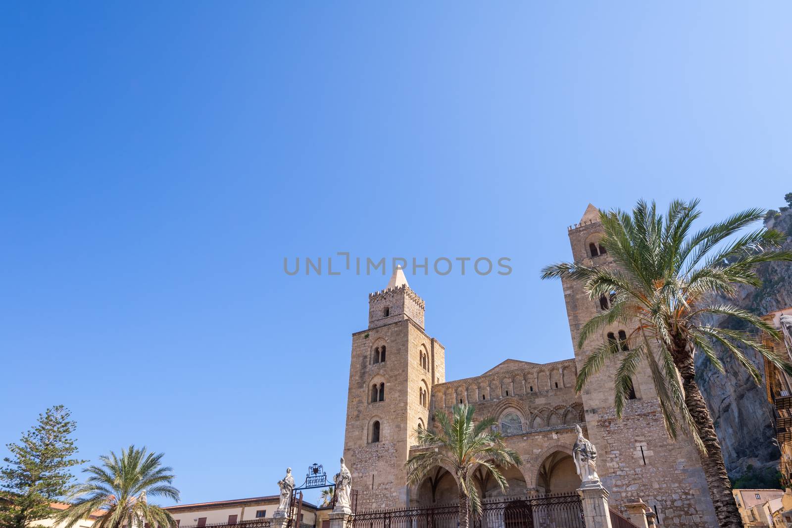 The towers of Duomo di Cefalù Cathedral with clear blue sky and copy space in Cefalu Sicily Italy from an angled view.