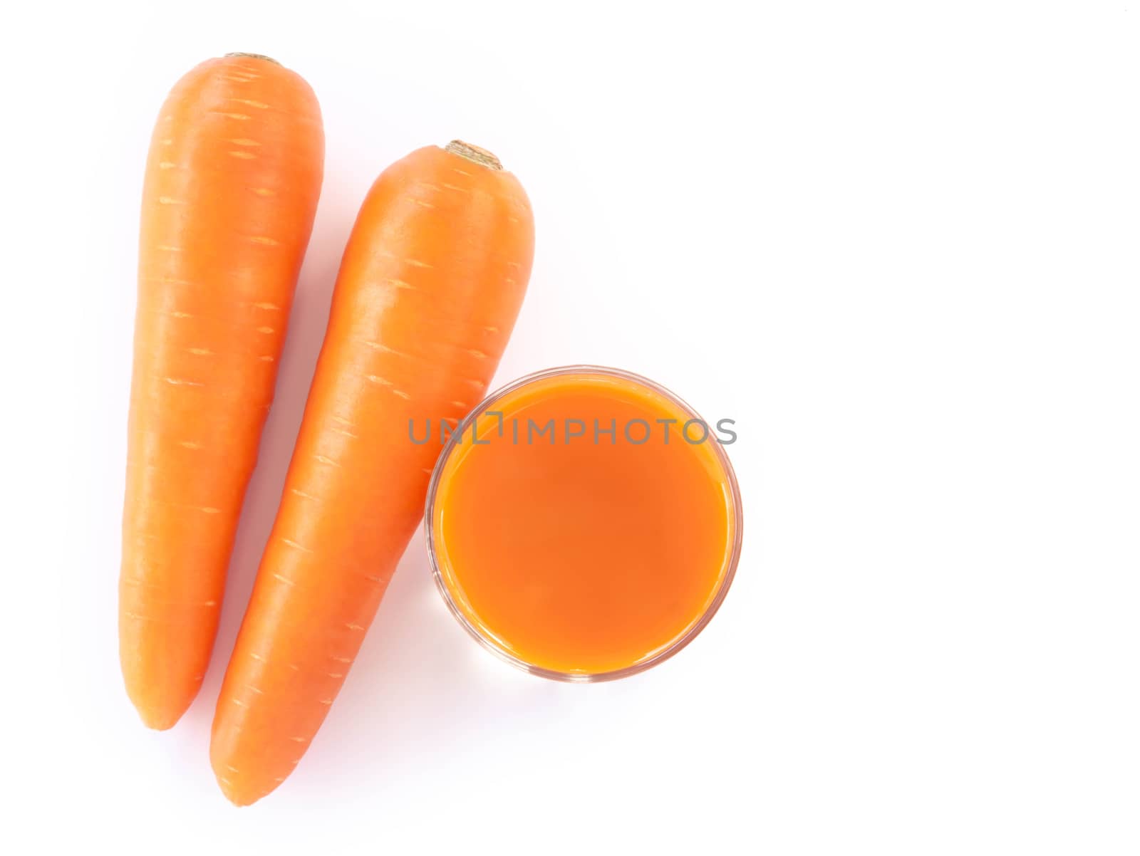 Closeup top view glass of carrot juice and fresh carrot isolated by pt.pongsak@gmail.com