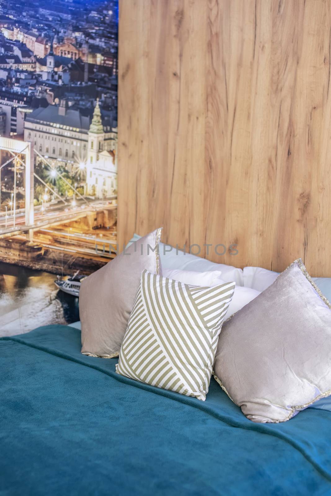 Detail shot of bedroom with modern stylish cityscape theme wallpaper and pastel colour pillows