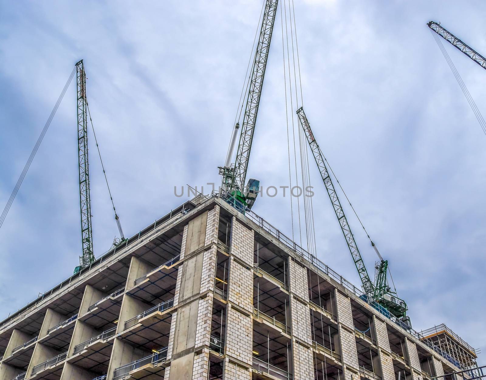 Several cranes on constructions sites at high buildings all over Europe.