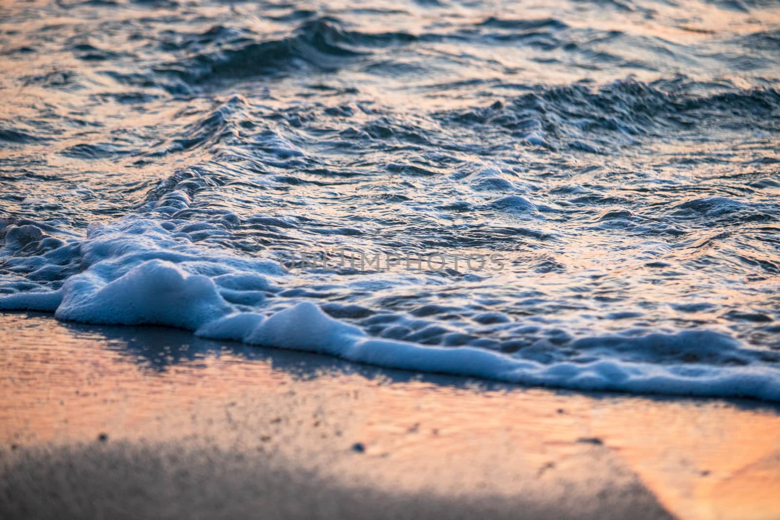 waves on the beach at sunset by Khankeawsanan