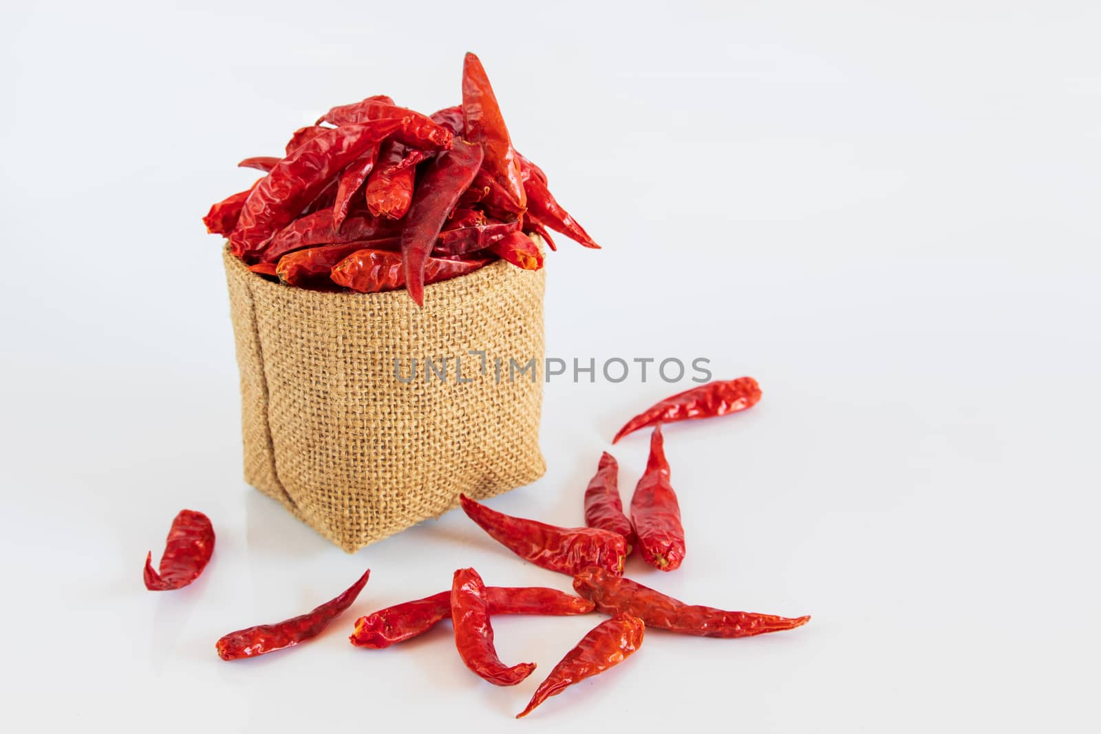 red dried chili pepper in brown bag on white background.