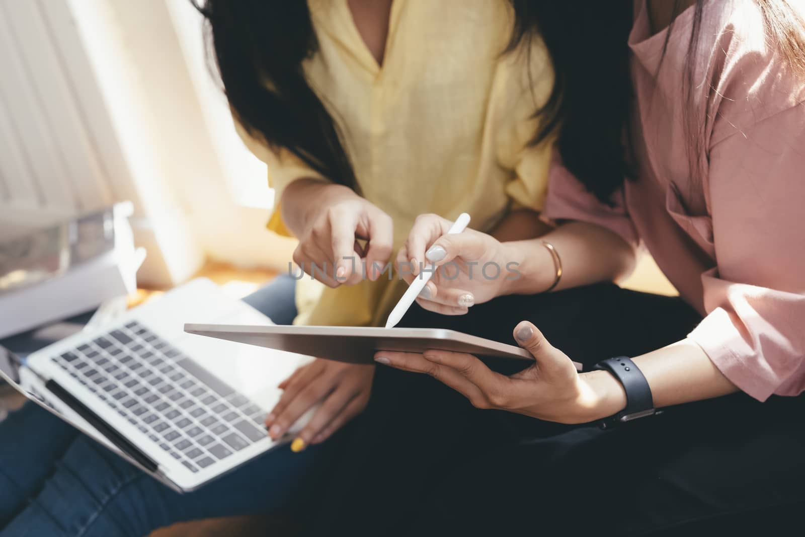 Close up women using smartphones discussing mobile apps concept, using cellphones synchronizing information online with laptop,.