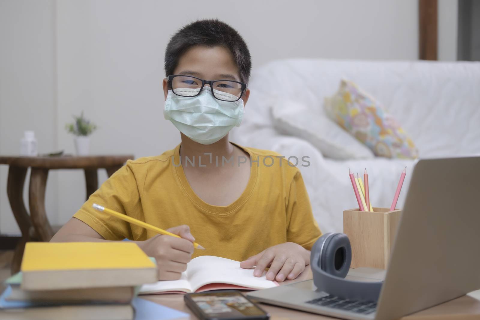 Boy wearing face masks online study homeshcooling at home.
