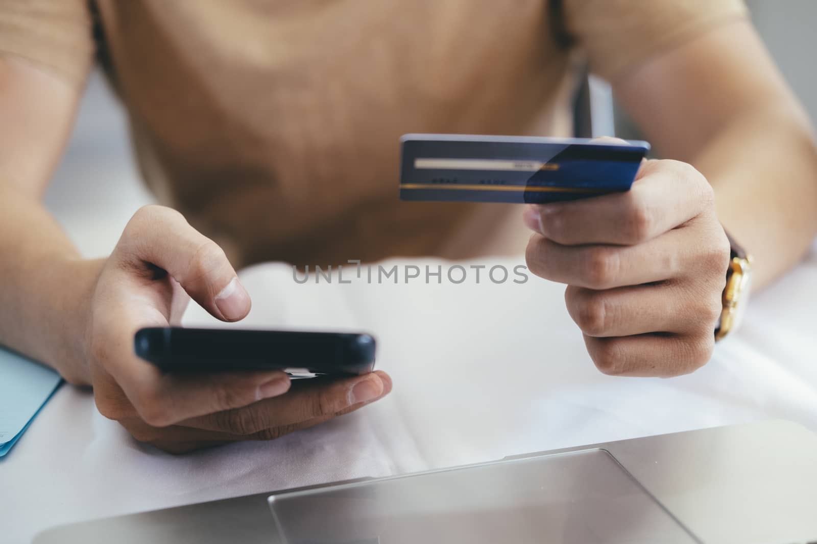 Online shopping and paying with credit card. Closeup hands holding credit card and using mobilephone and online shopping.