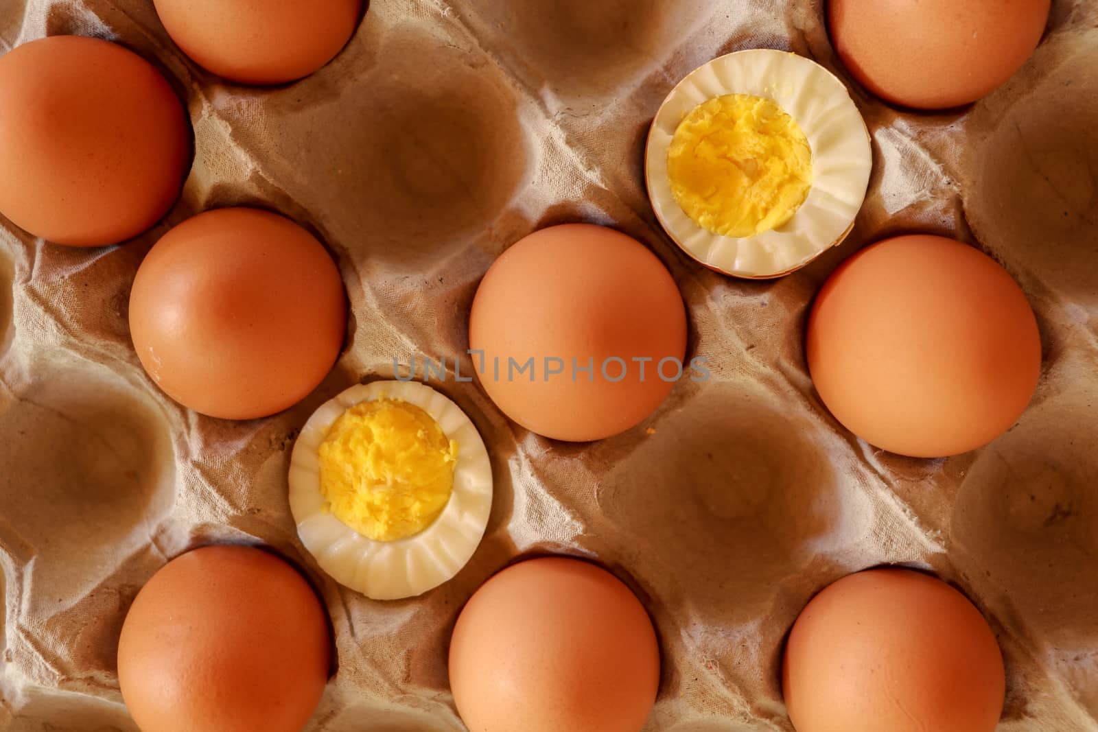 Eggs in paper tray. one soft-boiled. view from top. Boiled halve by Sanatana2008