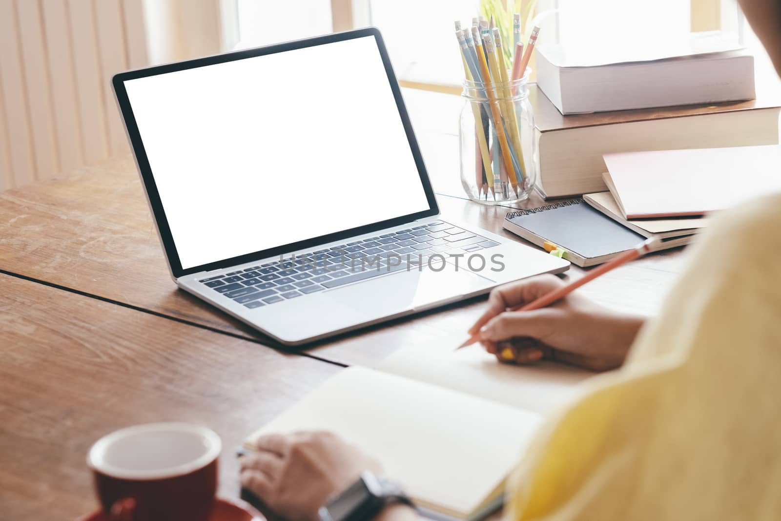 Young woman using computer and writing at home by ijeab