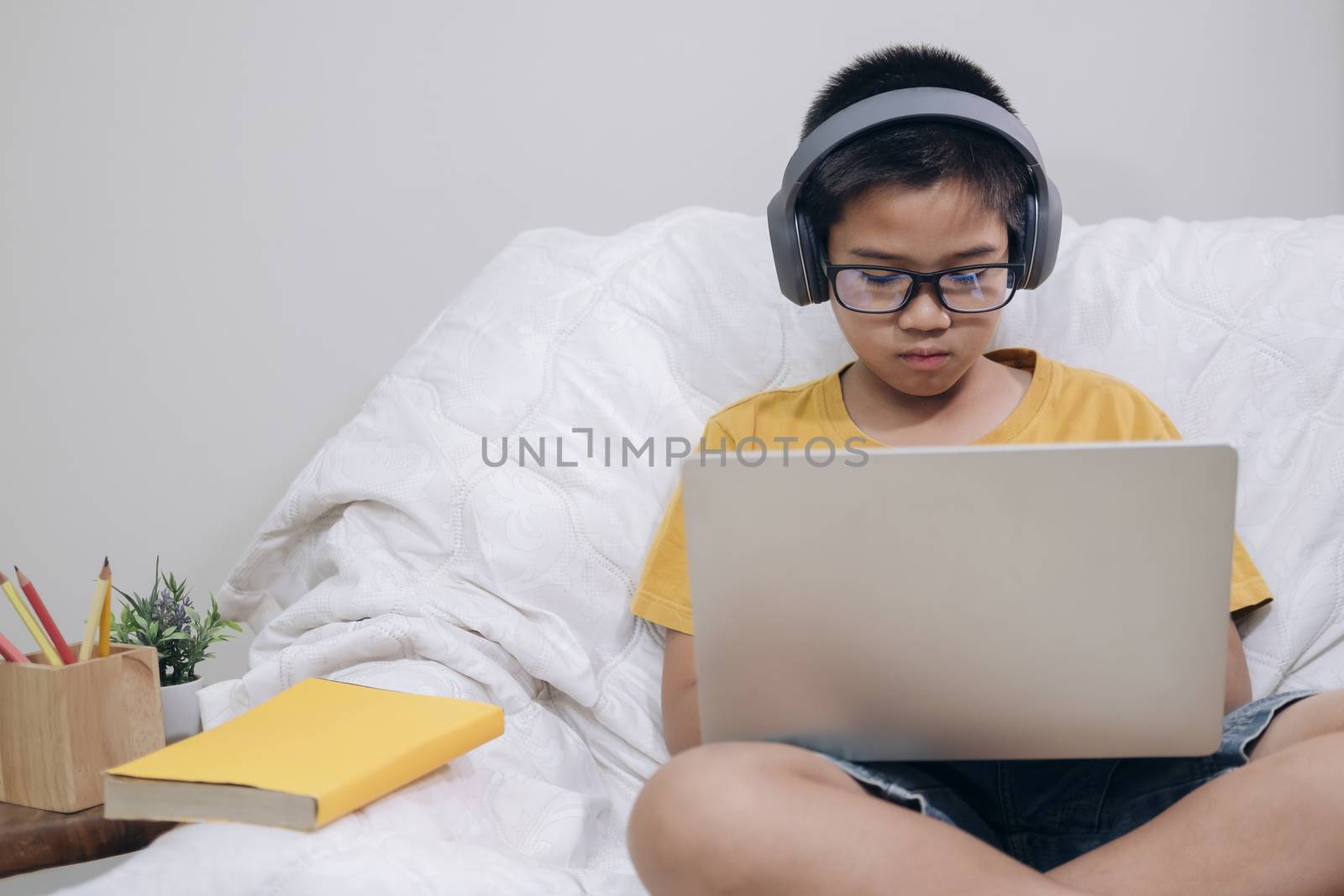 Cheerfully boy excited using computer online learning schoolwork. Asian boy enjoy self study with e-learning at home. Online education and self study and homeschooling concept.