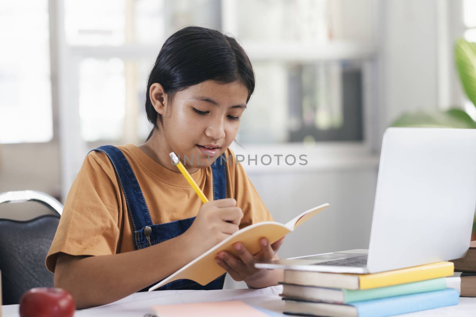 Happy asian girl learning online at home. Education and e-learning concept.