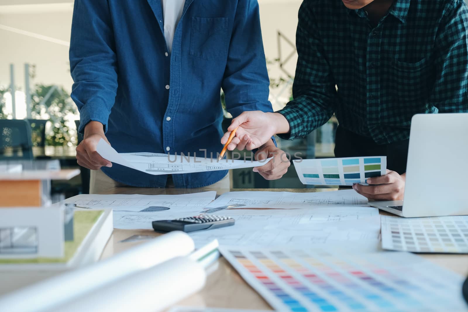 Image of engineer meeting for architectural project working with partner and engineering tools on workplace.