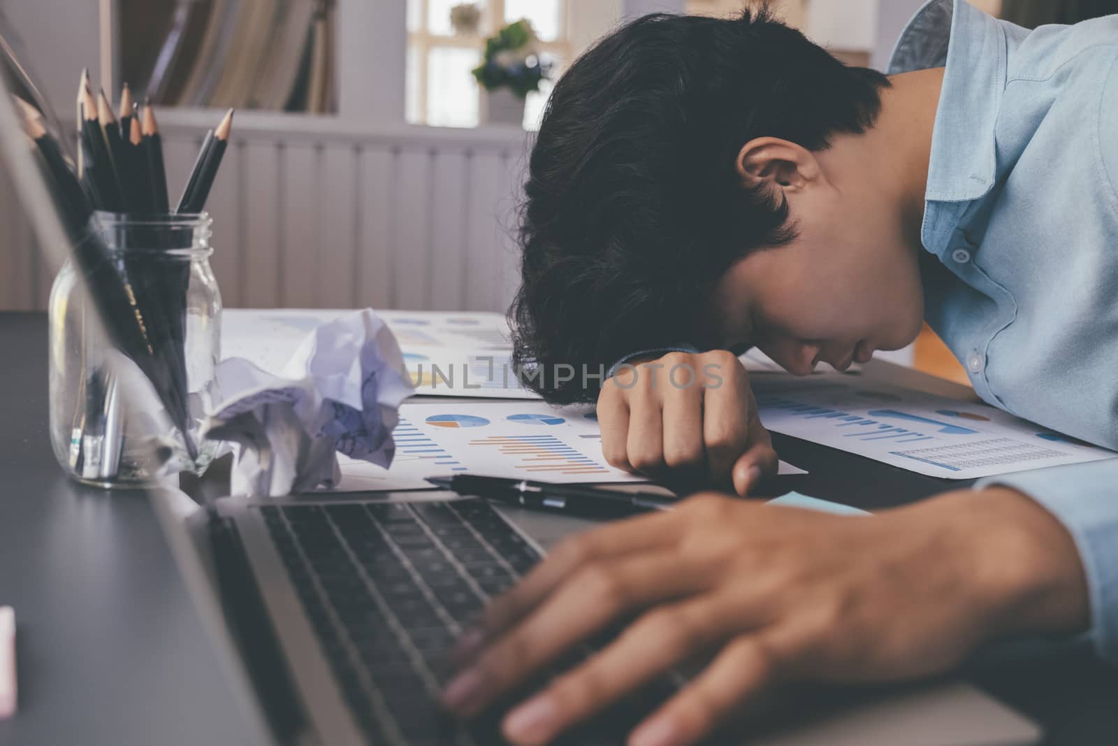 Businessman tried and stressed sleep on working desk. by ijeab