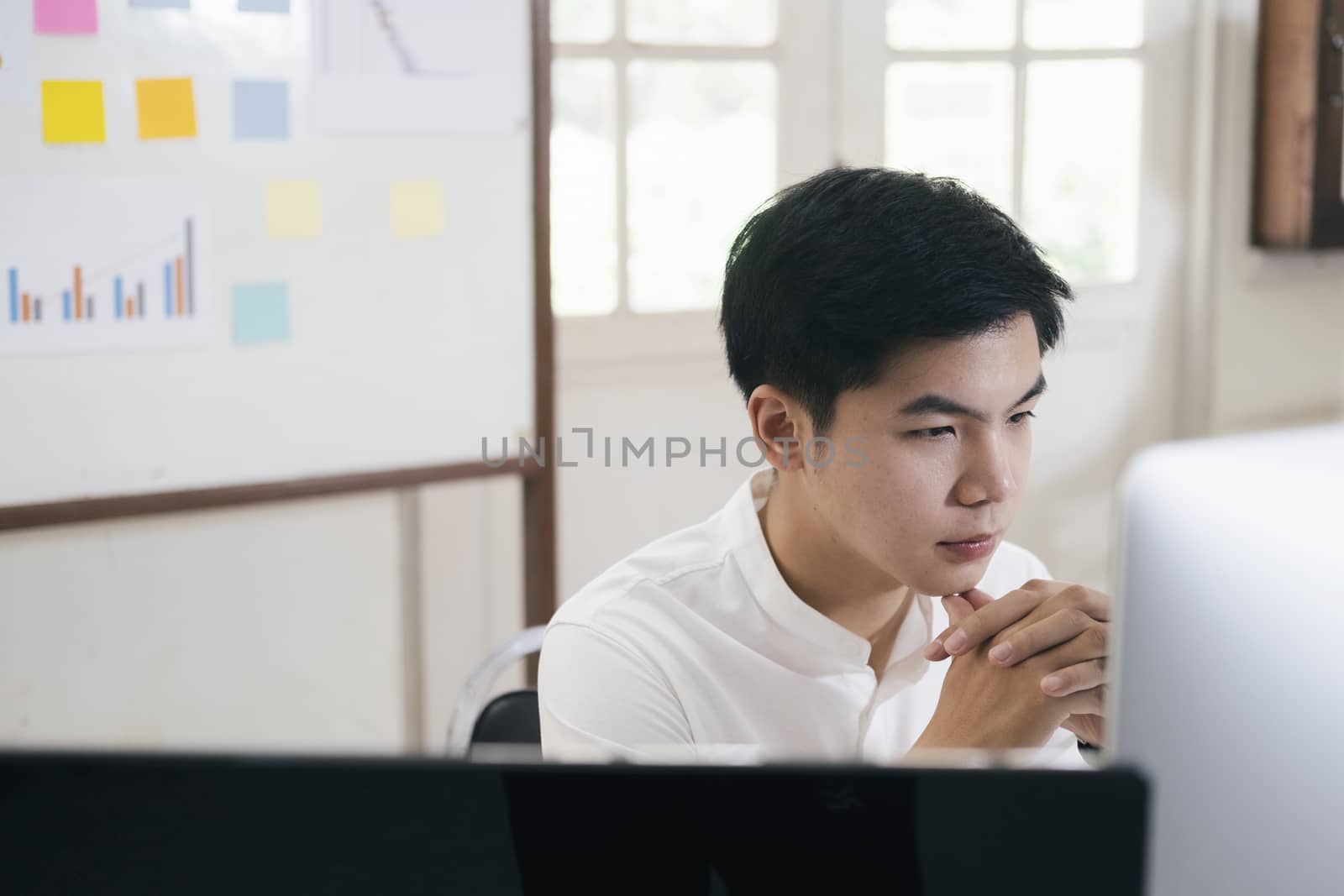 Young businessman analyze online marketing in his computer by ijeab