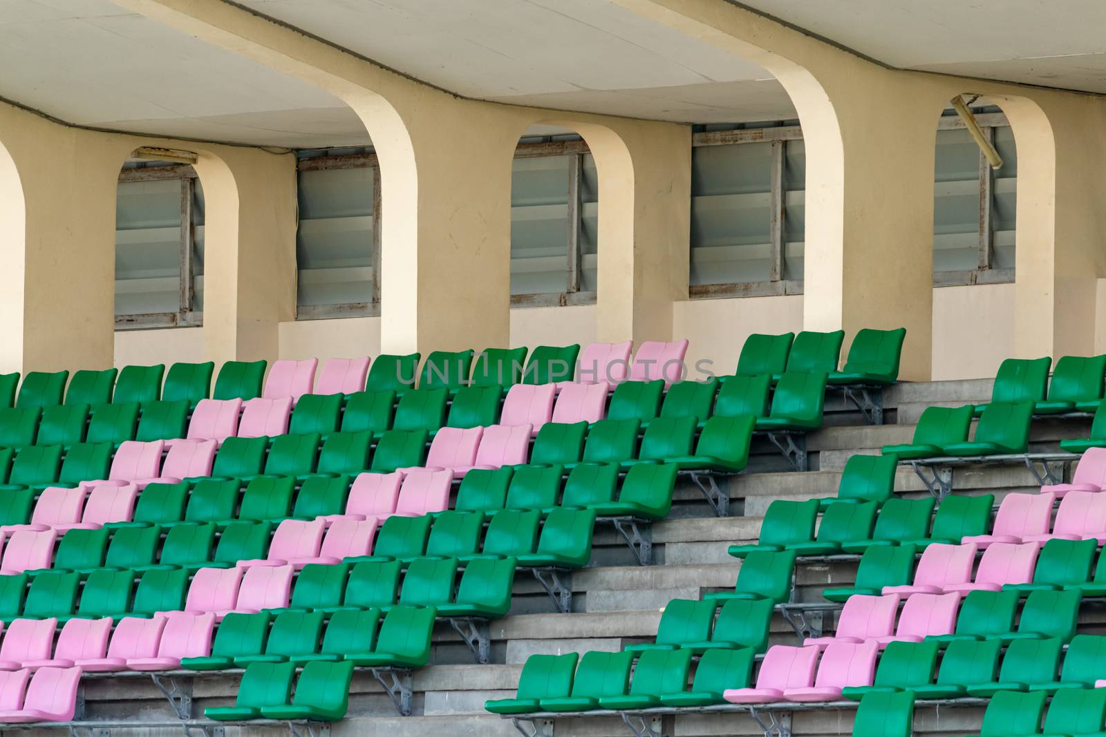 empty green and pink seats in sport stadium