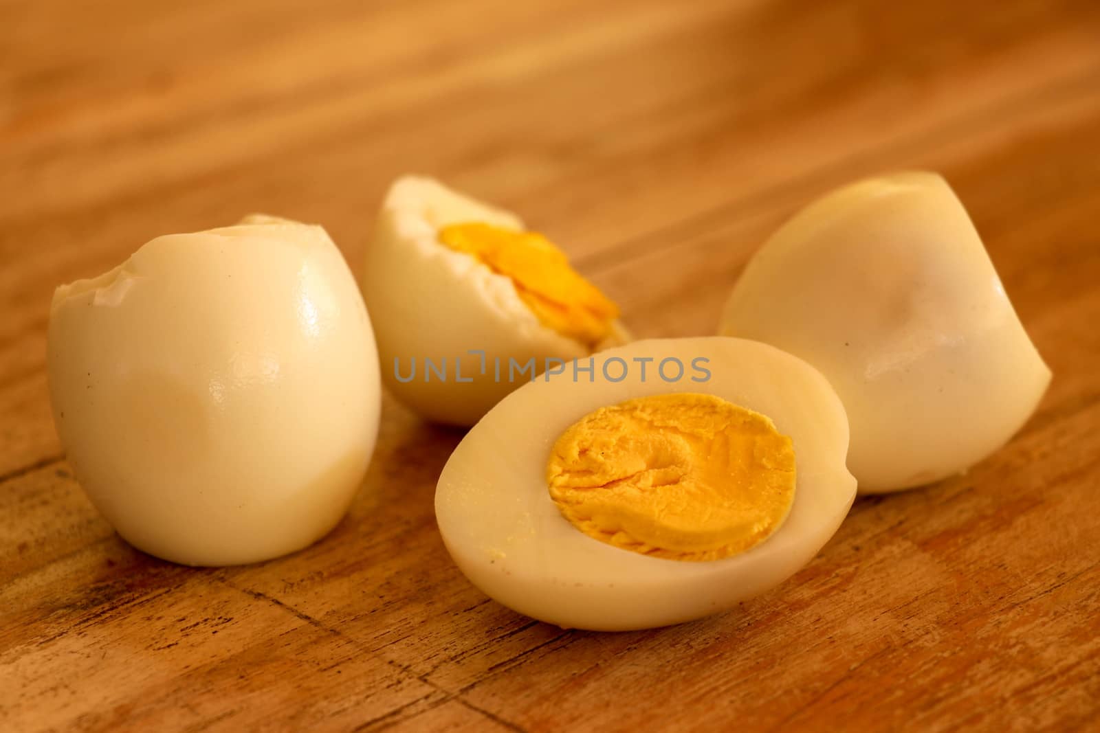 Hard boiled eggs, sliced in halves on wooden background.