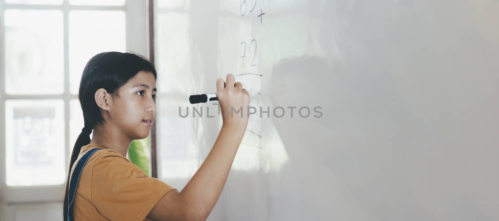 School child thinking while doing mathematics problem by ijeab