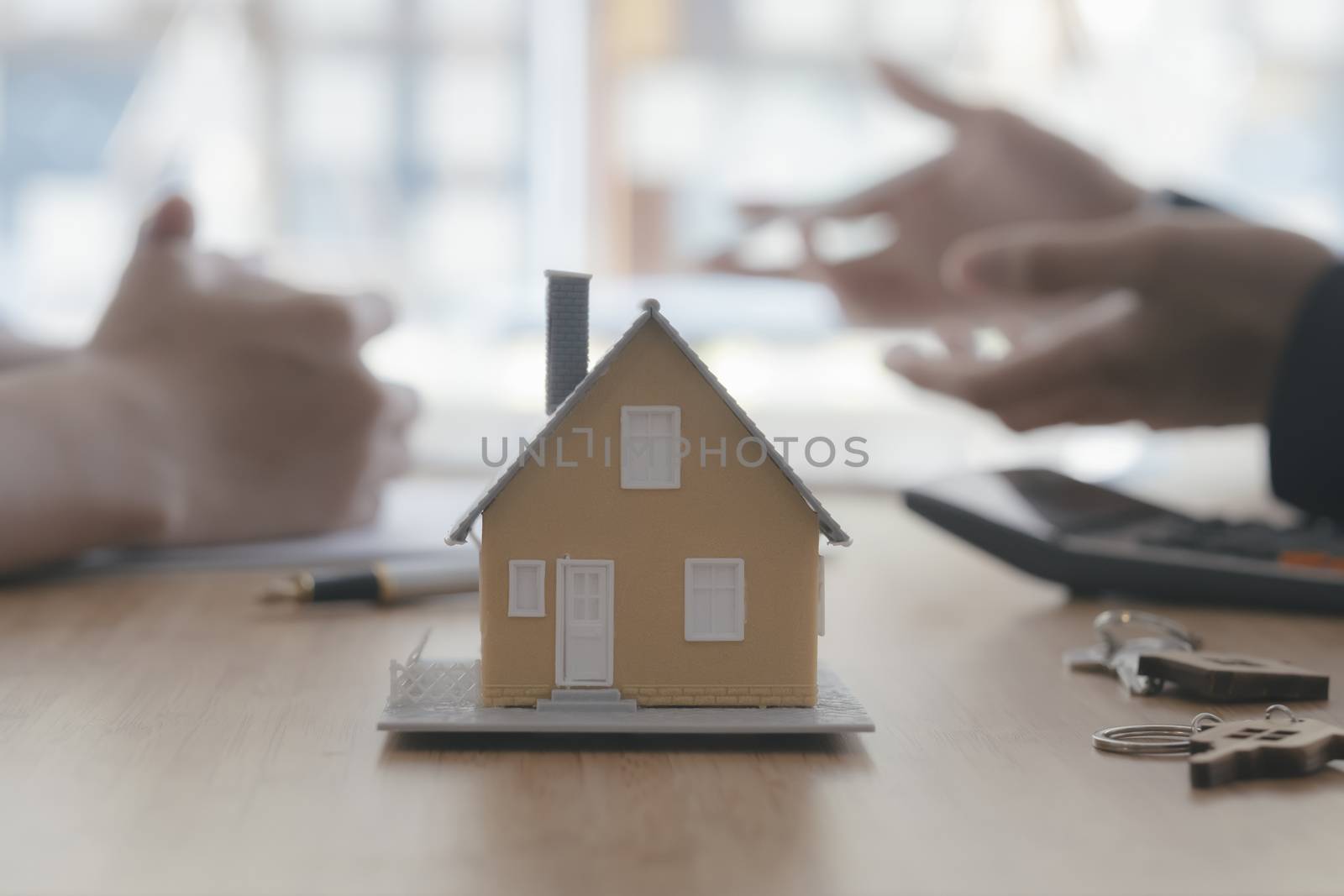 Close up house model on blur background of real estate agent and by ijeab