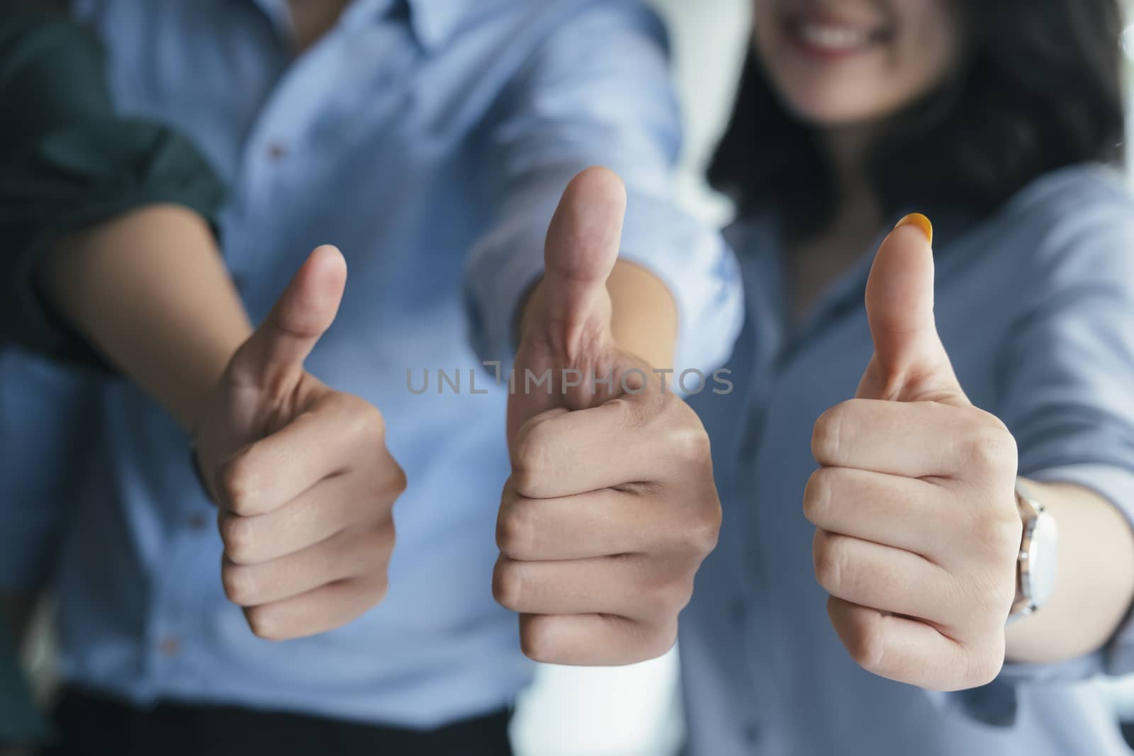 Closeup gruop of business people giving thumbs up. Group of people show confirm with thumb up.