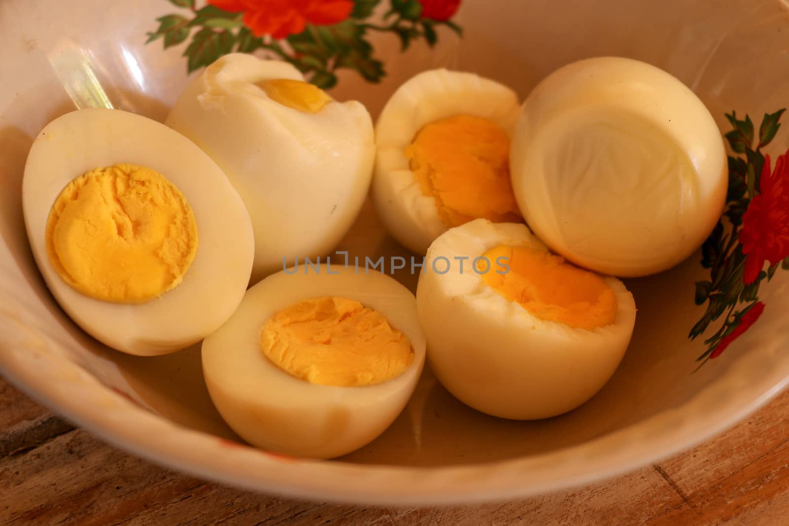 close up of half boiled eggs on wooden bowl.