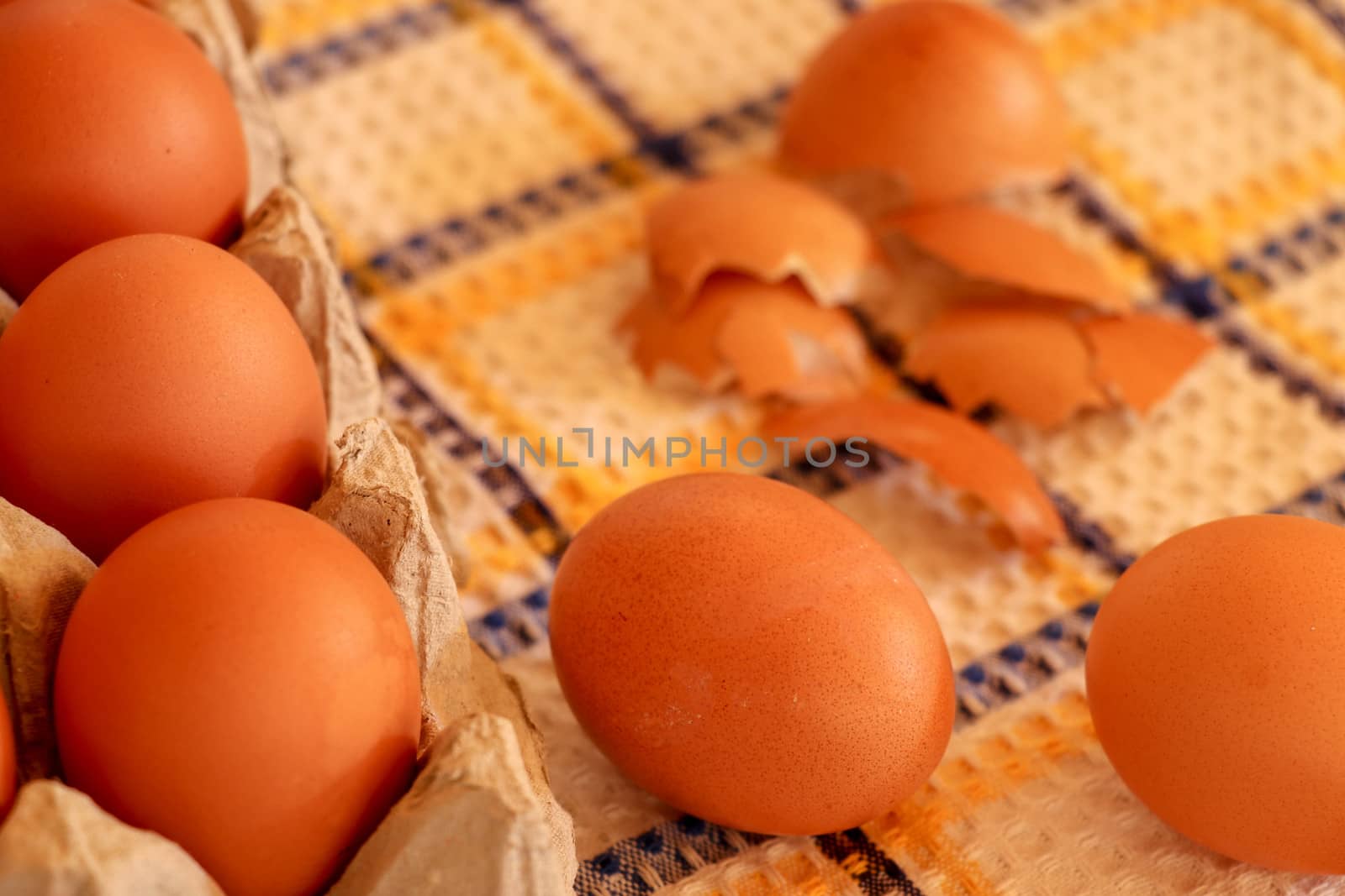 Brown chicken egg on vintage tablecloth and eggs in the basket.
